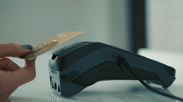 Payment by NFC credit card. The woman pays by contactless credit card. Wireless payment