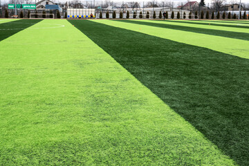 Artificial green grass on professional soccer field. An outdoor artificial football field awaiting...