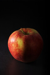 Fototapeta na wymiar An apple against black background