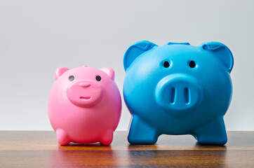 Pink and blue piggy bank on table background.