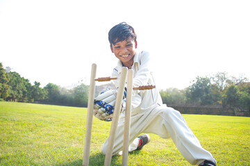 a boy wicket keeper stumping during cricket game