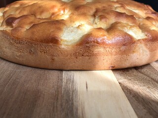 The apple pie is on a wooden board. It's time to drink tea and enjoy homemade cakes. Background. Macro.