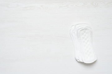 Pile of daily feminine pads on the white table flat lay background with copy space.