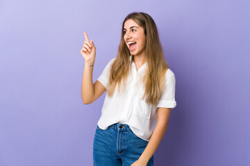 Young woman over isolated purple background intending to realizes the solution while lifting a finger up