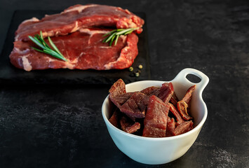 Jerky snack high in protein from lean beef. smoked, dried food with meat cuts and pepper.
