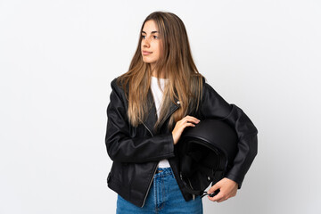Young Woman holding a motorcycle helmet over isolated white background looking side