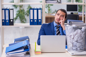 Young businessman employee rejecting new ideas with lots of pape