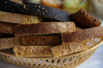 sliced coarse gray bread in a wicker bowl on the table