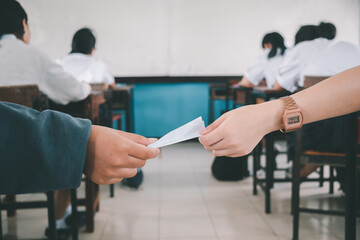 Students passing notes to each other secretly during class