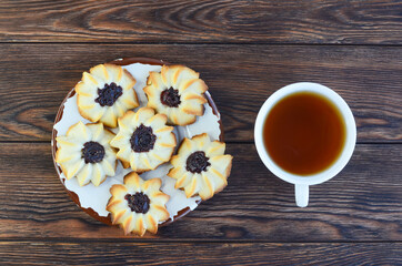homemade shortbread cookies kurabye and a cup of tea on a textured wooden table top view