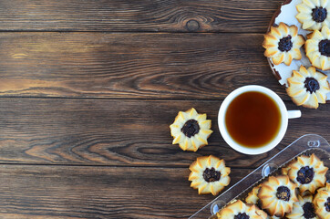 homemade shortbread cookies kurabye and a cup of tea on a textured wooden table top view