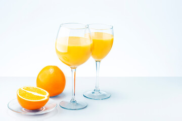 Two glasses of orange juice cocktail and fruits on light grey surface with copy space.