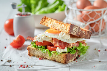Tasty sandwich with egg, vegetables and bacon. British breakfast.