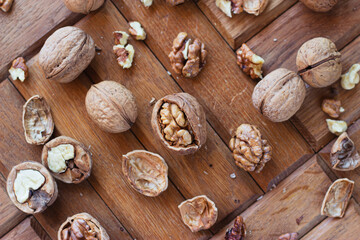 broken walnuts on a wooden background. split nuts near the nutcracker