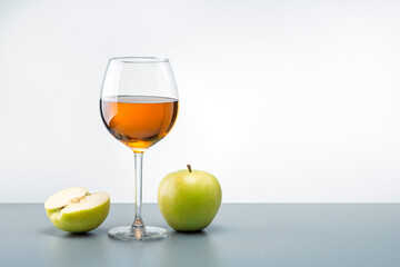 A glass of apple juice with green apples on the table with copy space.