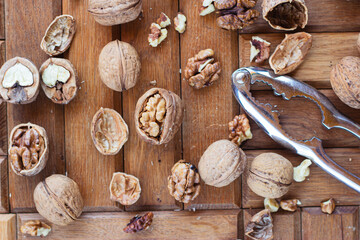 broken walnuts on a wooden background. split nuts near the nutcracker