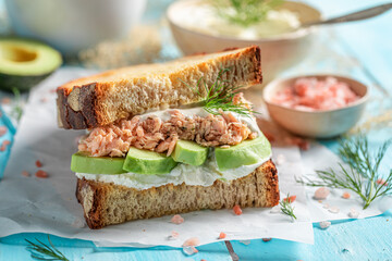 Tasty sandwich with salmon and avocado for healthy breakfast.