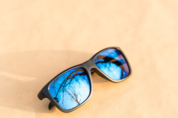 Classic Sunglasses with blue lenses and black frame shoot outside in a summer day closeup. Selective focus. High quality photo