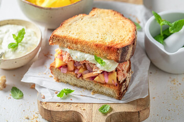 Homemade sandwich with chicken, fruits, onion and herbs.