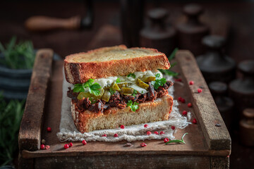 Homemade sandwich with shredded beef and gherkin with herbs.