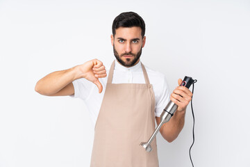 Man using hand blender isolated on white background showing thumb down sign