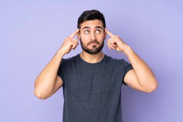 Fototapeta na wymiar Caucasian handsome man having doubts and thinking over isolated purple background