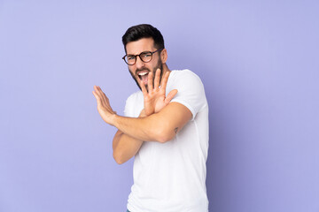 Caucasian handsome man over isolated background nervous stretching hands to the front