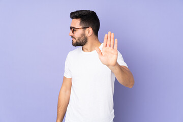 Caucasian handsome man over isolated background making stop gesture and disappointed