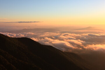 八ヶ岳の風景。朝日にオレンジ色に染まる雲海。