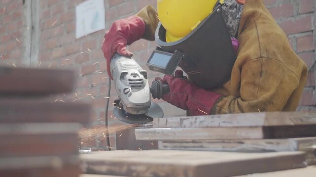 Trabajador latino lijando metal
