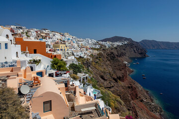 Fototapeta premium Der romantische Ort Oia auf der Insel Santorin zieht sich entlang des Kraterrandes der Caldera. Ein perfekter Ort für Flitterwochen