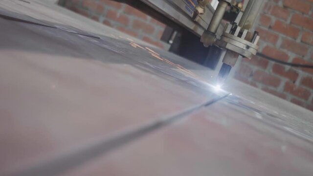 Maquina pesada cortando metal con rayo laser