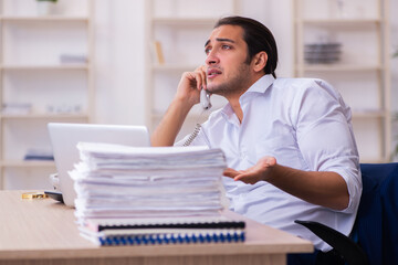 Young businessman employee unhappy with excessive work in the office