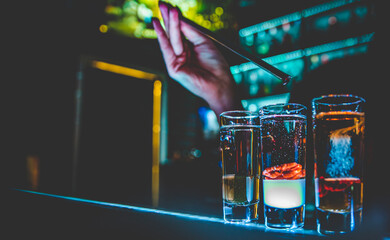 bartender making collection of colorful shots. Set of cocktails at the bar