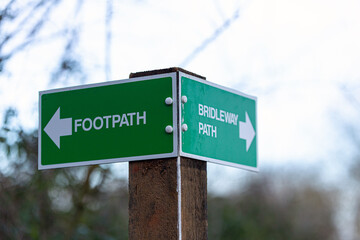 Rural 2 way signpost showing a footpath and a bridal way. Countryside, directions, lost concept