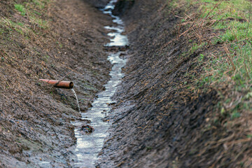 A small sewage run off pipe polluting the countryside. Ecosystem, pollution, polluted, environment concept