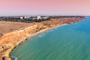 Fototapeta na wymiar Seascape with sea and city on the clay steep coast. Aerial view of Chornomorske, Odesa, Ukraine