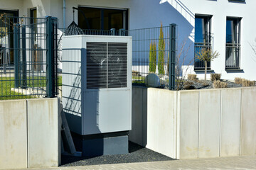 Luftwärmepumpe/Klimaanlage für Heizung und Warmwasser vor einem Wohnhaus