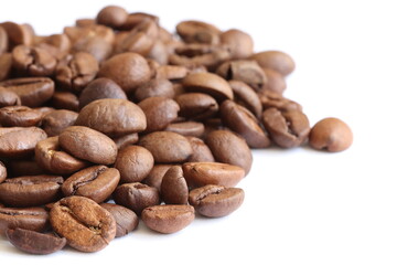 Many grains of aromatic divine coffee on a light background close-up.