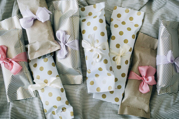 Many of DIY gift boxes on a pink background, not very neat gifts, but made with love