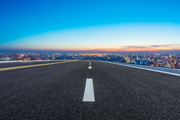 Empty asphalt road and Shanghai skyline with buildings at night.