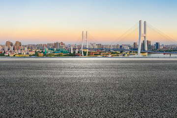 Asphalt highway and city skyline with bridge at dusk in Shanghai,China.