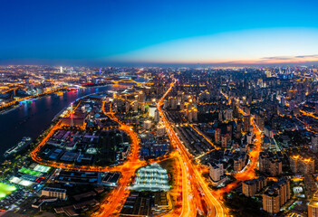 Aerial view of modern city skyline and buildings at night in Shanghai.
