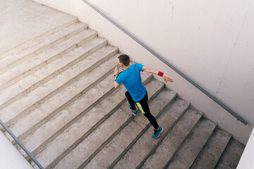 Young man running upstairs on city stairs. Fitness, sport, people, exercising and lifestyle concept