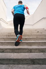 Young man running upstairs on city stairs. Fitness, sport, people, exercising and lifestyle concept