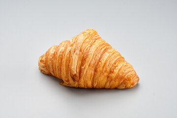 Fresh baked croissant. Warm fresh buttery croissant on a grey backgroundon. French croissant enjoyed world wide. Macro photography.