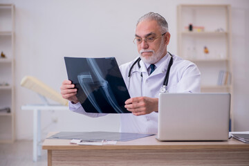 Old male doctor radiologist working in the clinic