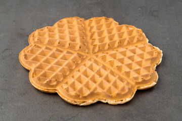 Single heart waffle on a dark stone background.
