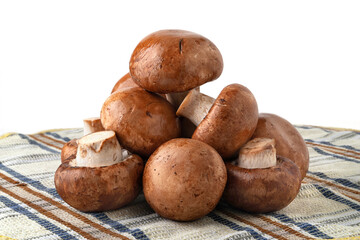 Champignon mushrooms on a towel. Brown champignons isolated on white. A bunch of mushrooms.