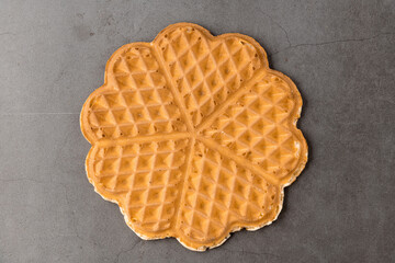 Single heart waffle on a dark stone background.